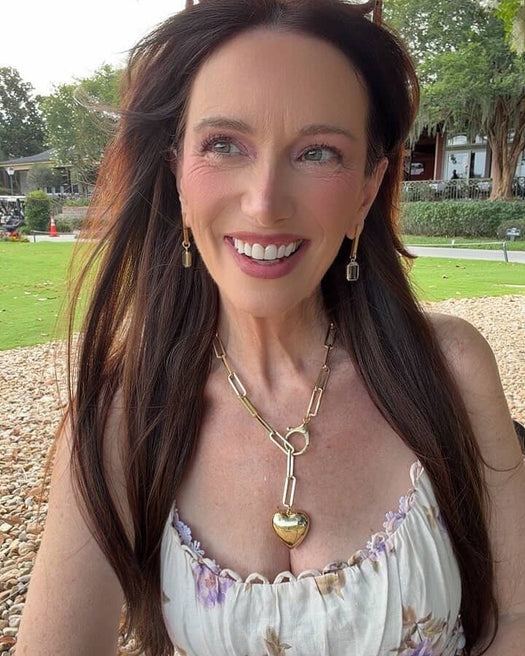 Woman wearing a floral dress with a gold necklace outdoors