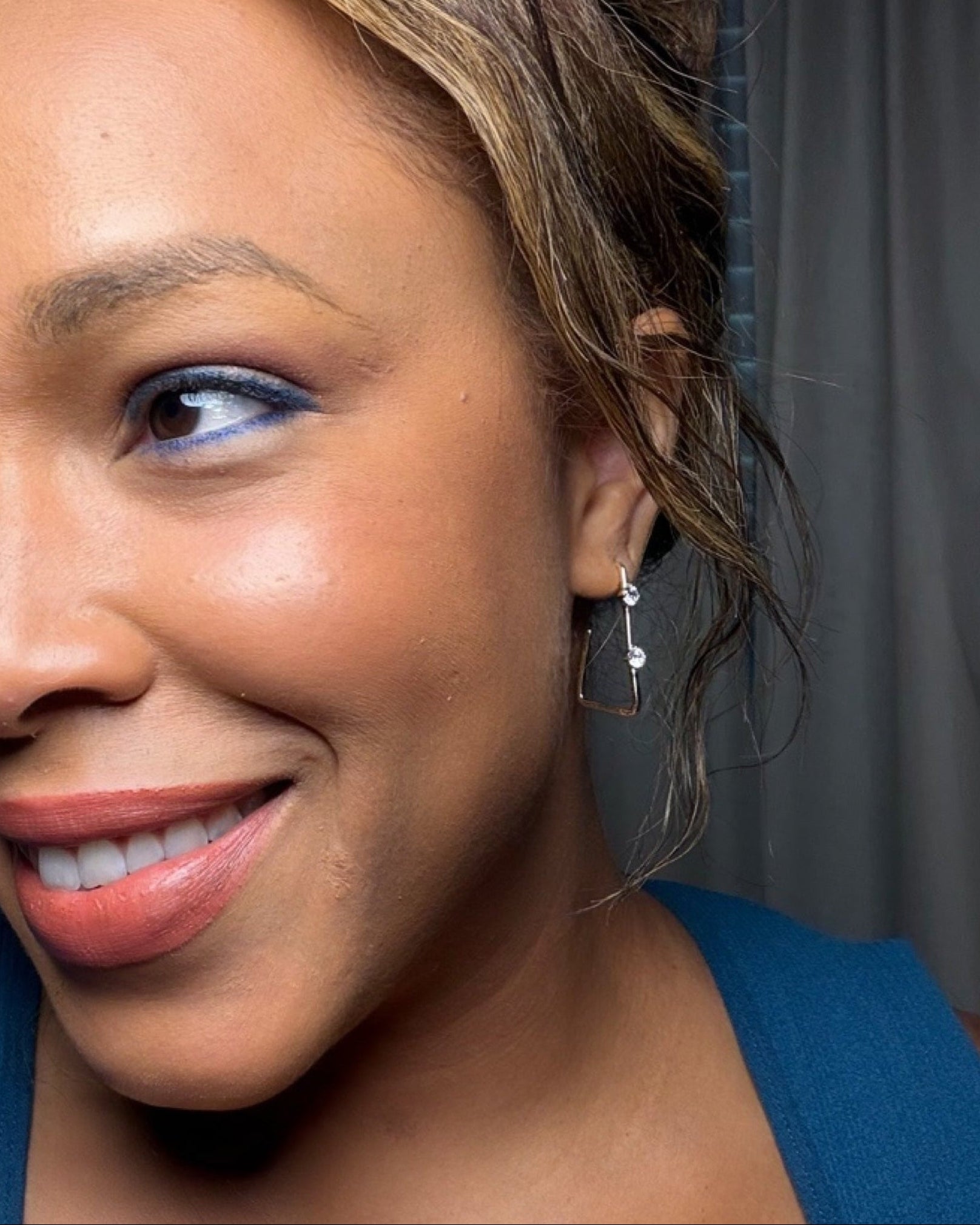 Woman wearing a blue top against a gray background